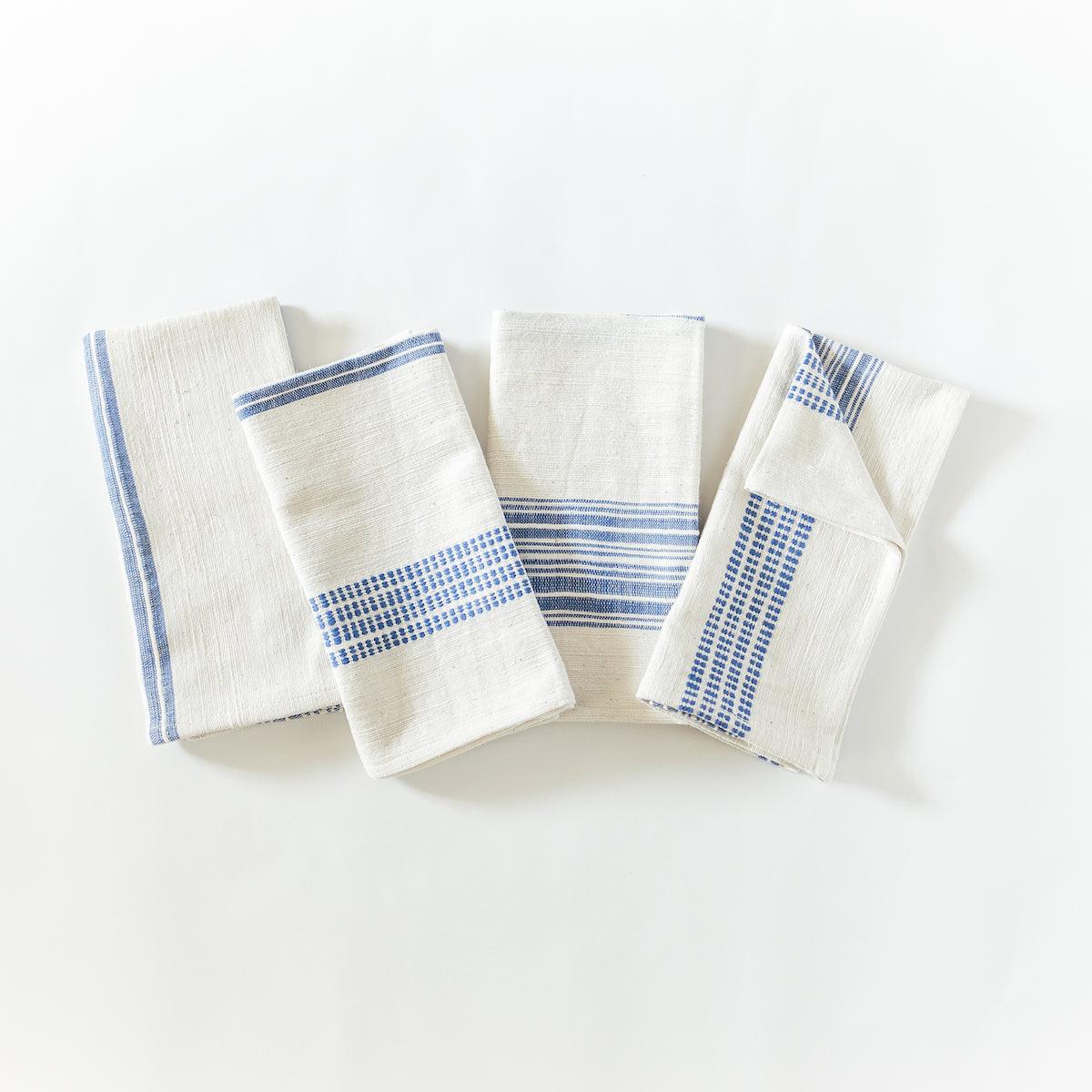 a set of four blue and white napkins