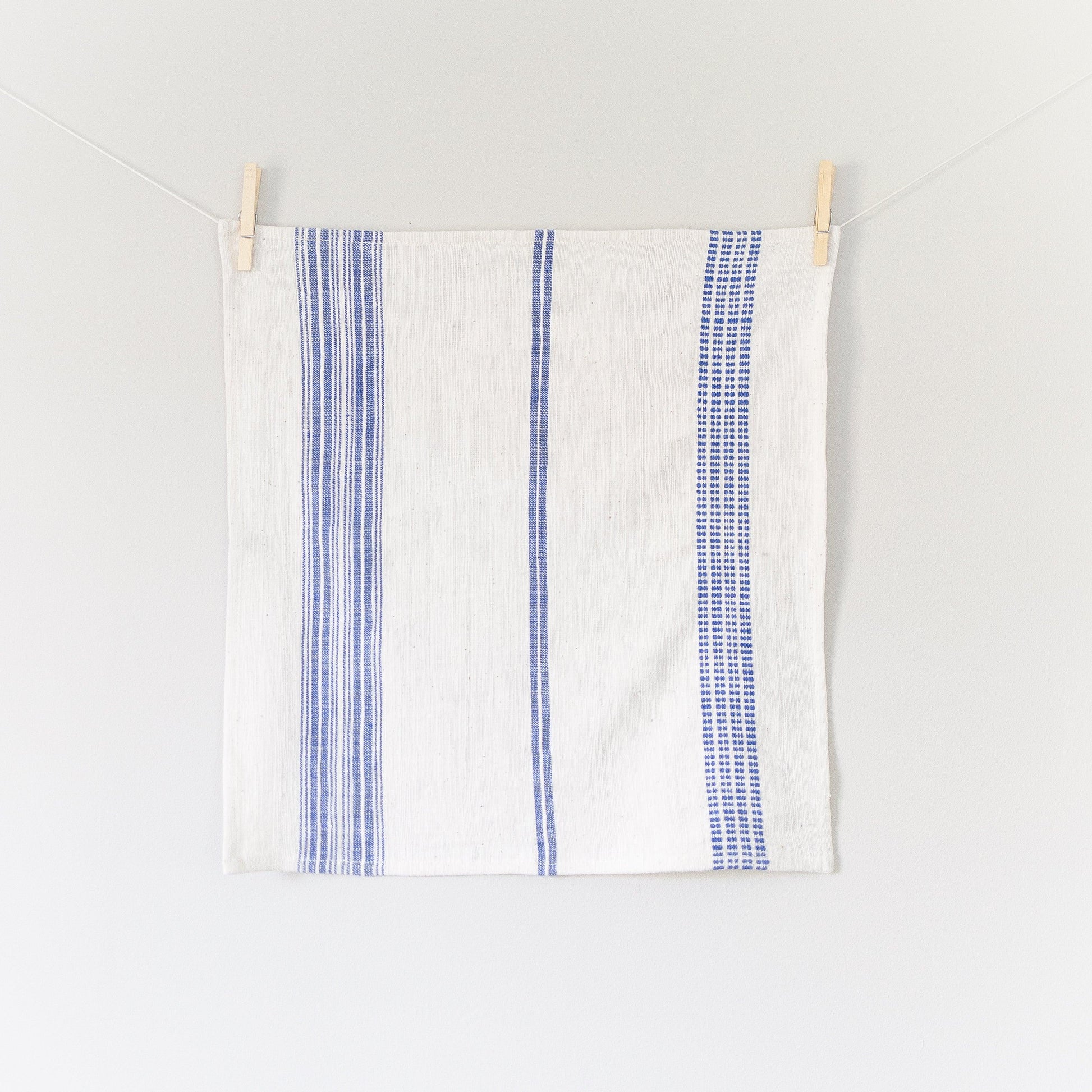 a blue and white napkin hanging on a clothes line