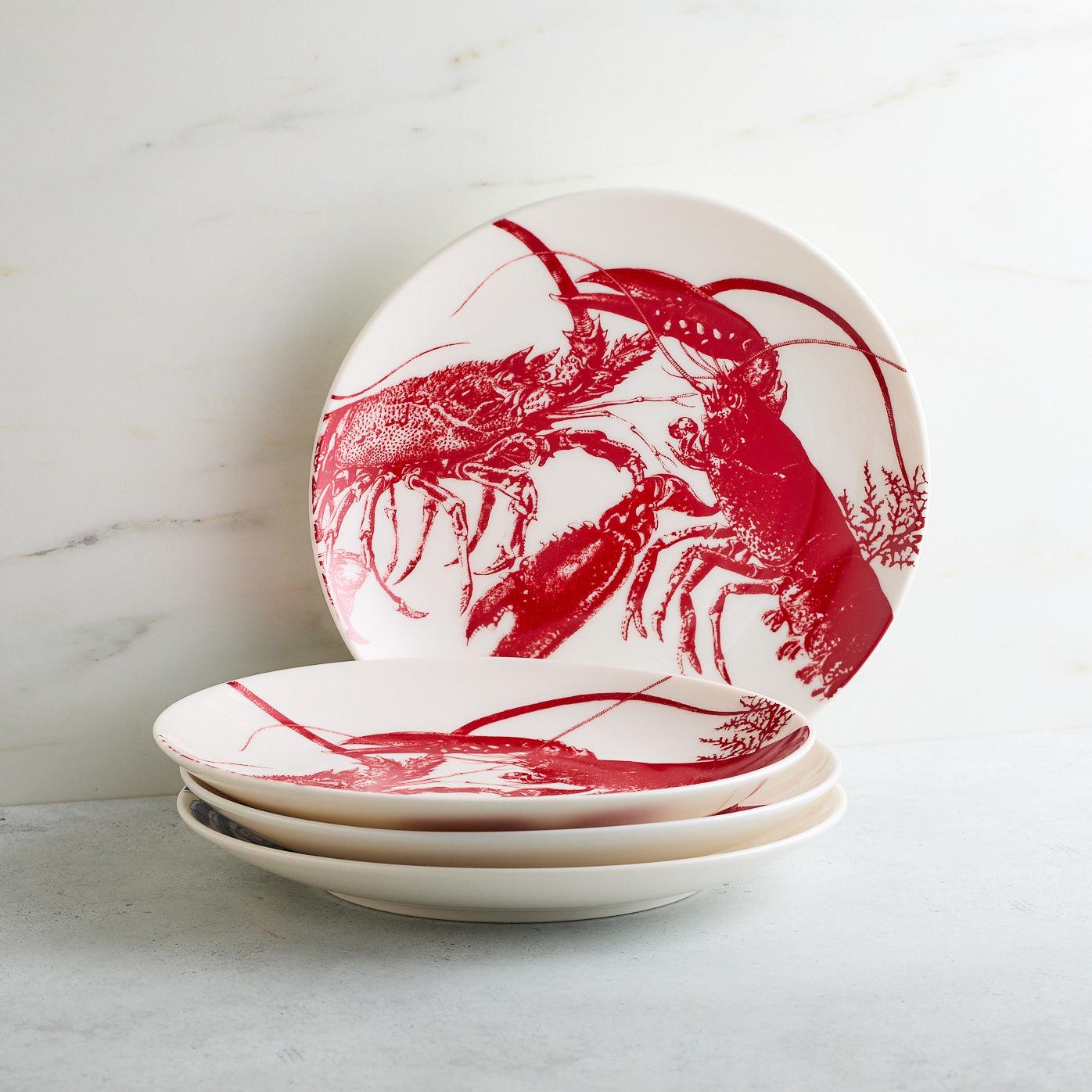 a set of four plates with red lobsters on them