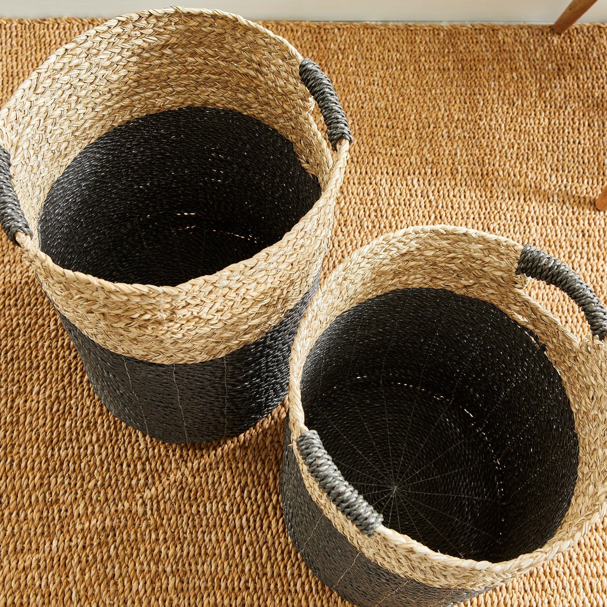 two woven baskets sitting on top of a rug