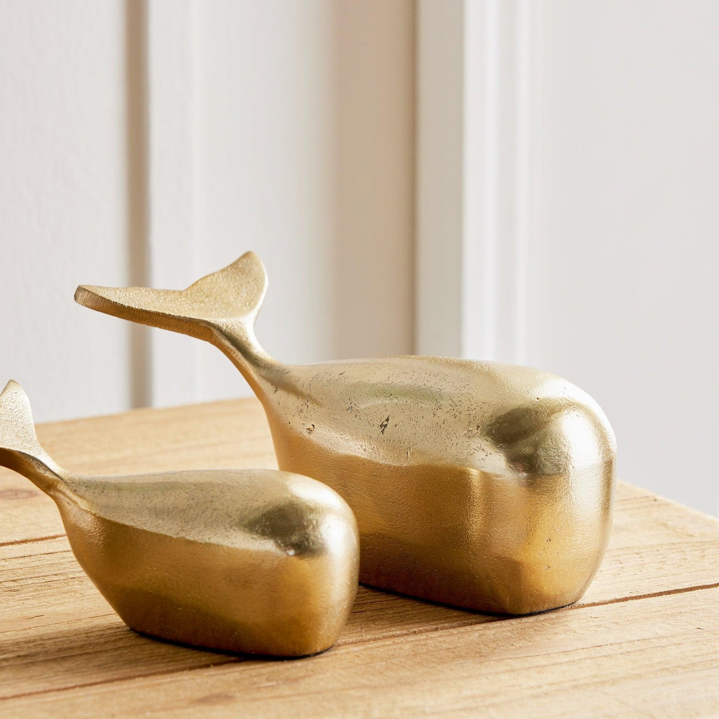 a pair of gold whale shaped sculptures 