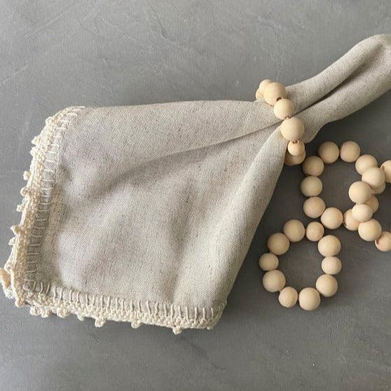 a napkin and beaded napkin rings on a table