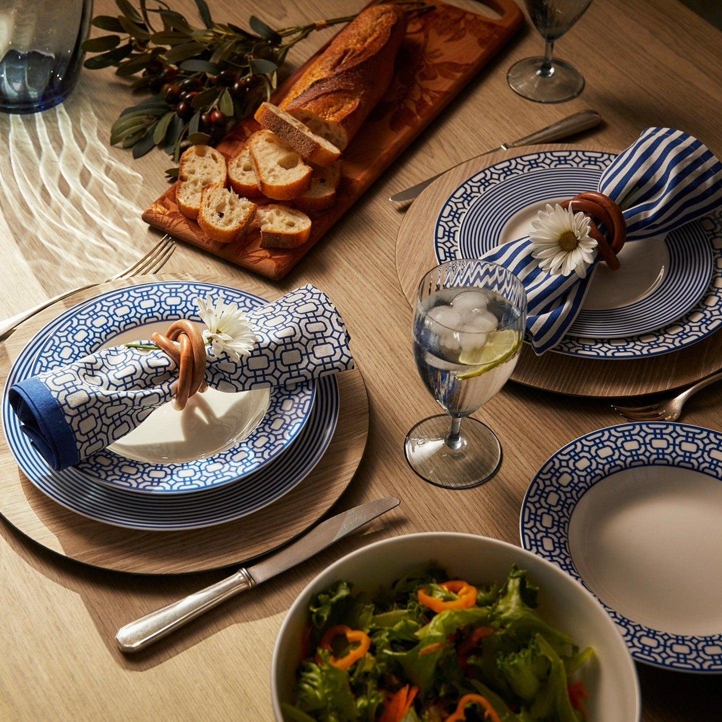 a wooden table topped with plates and bowls of food