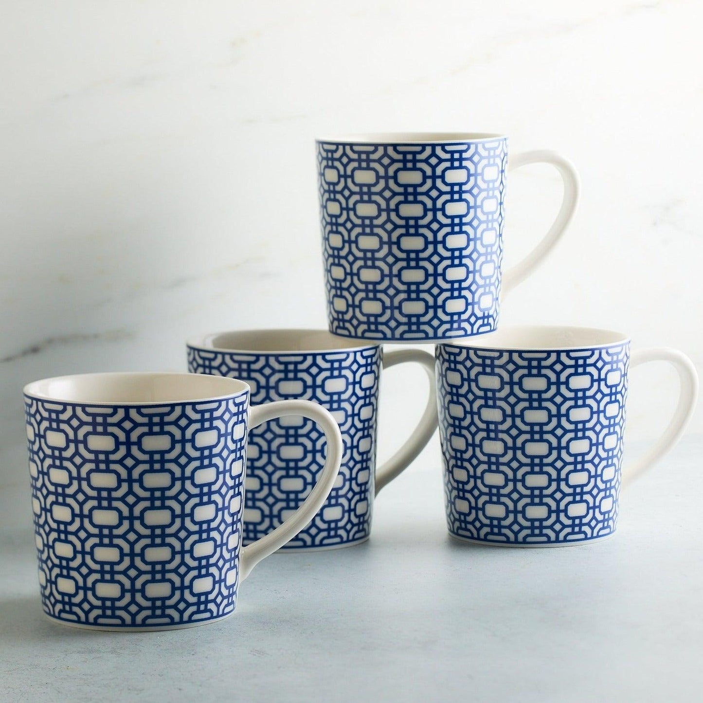 a set of four blue and white coffee mugs