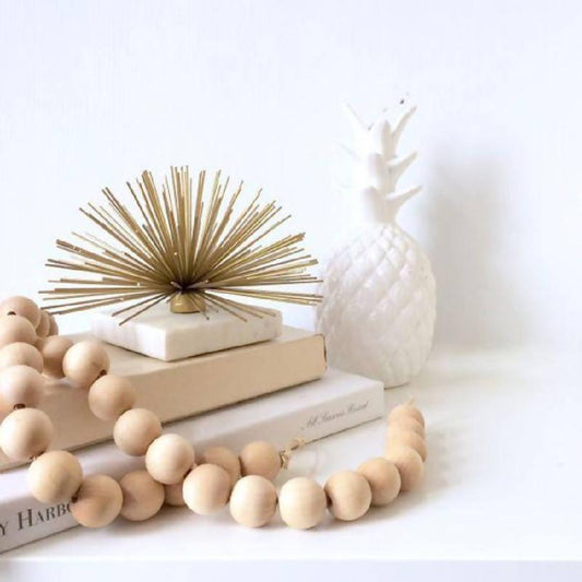 a wooden bead necklace sitting on top of a stack of books