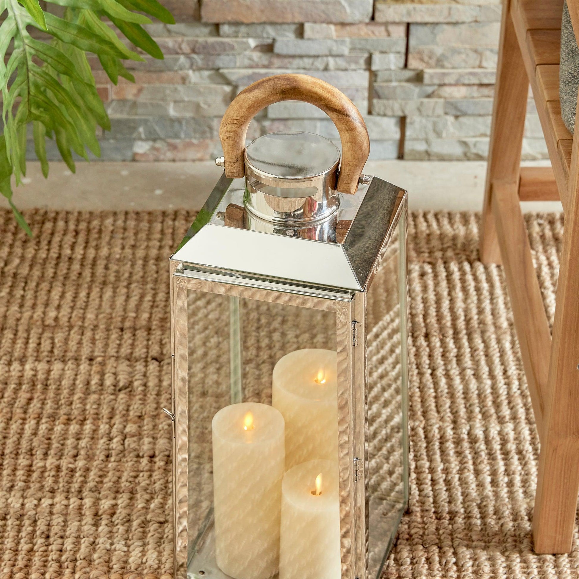 a lantern with three lit candles on a rug