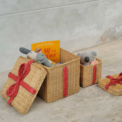	Large and small open rattan storage gift boxes filled with toys and a book, with lids alongside