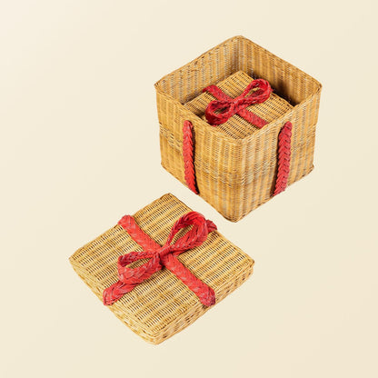	Small rattan gift box nested inside the larger open box, with the large red-bow lid beside it