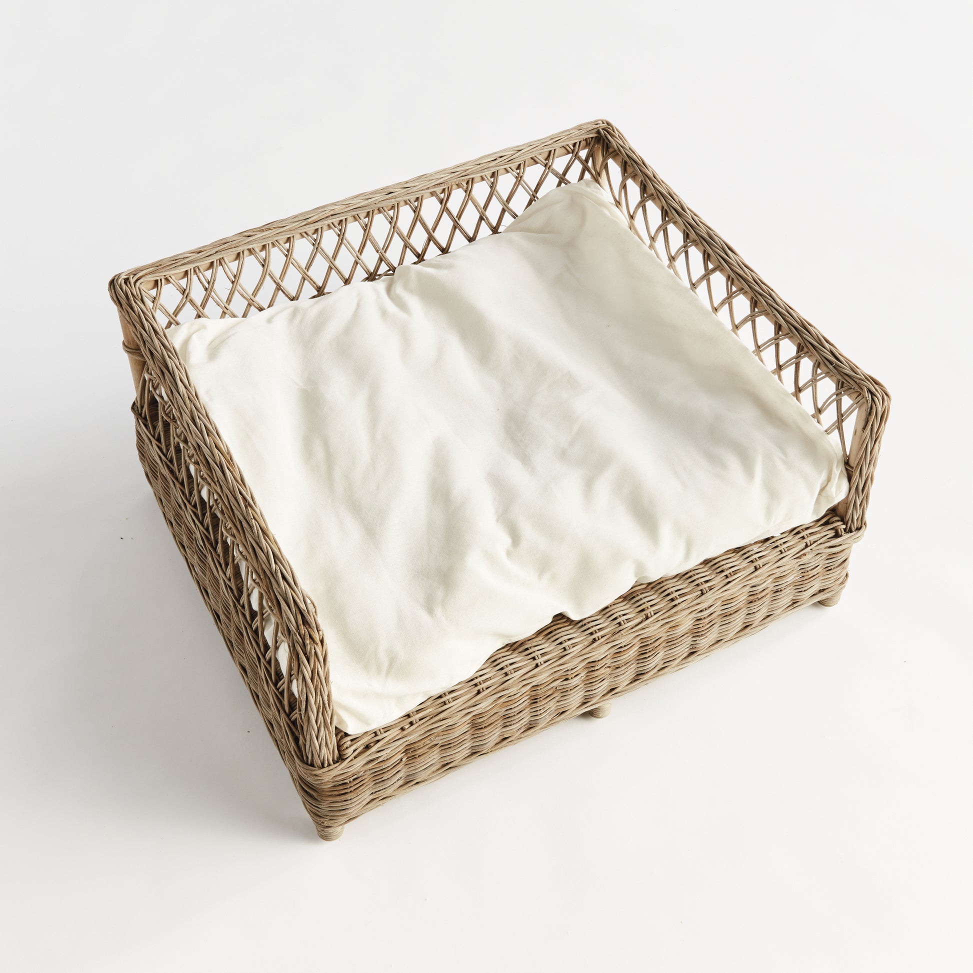 rattan dog bed with white cushion