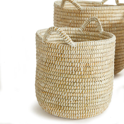 two woven baskets sitting side by side on a white surface
