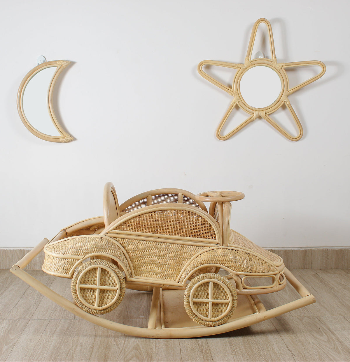 Side view of the vintage-inspired rattan rocking car showing its woven panels and rocking runners