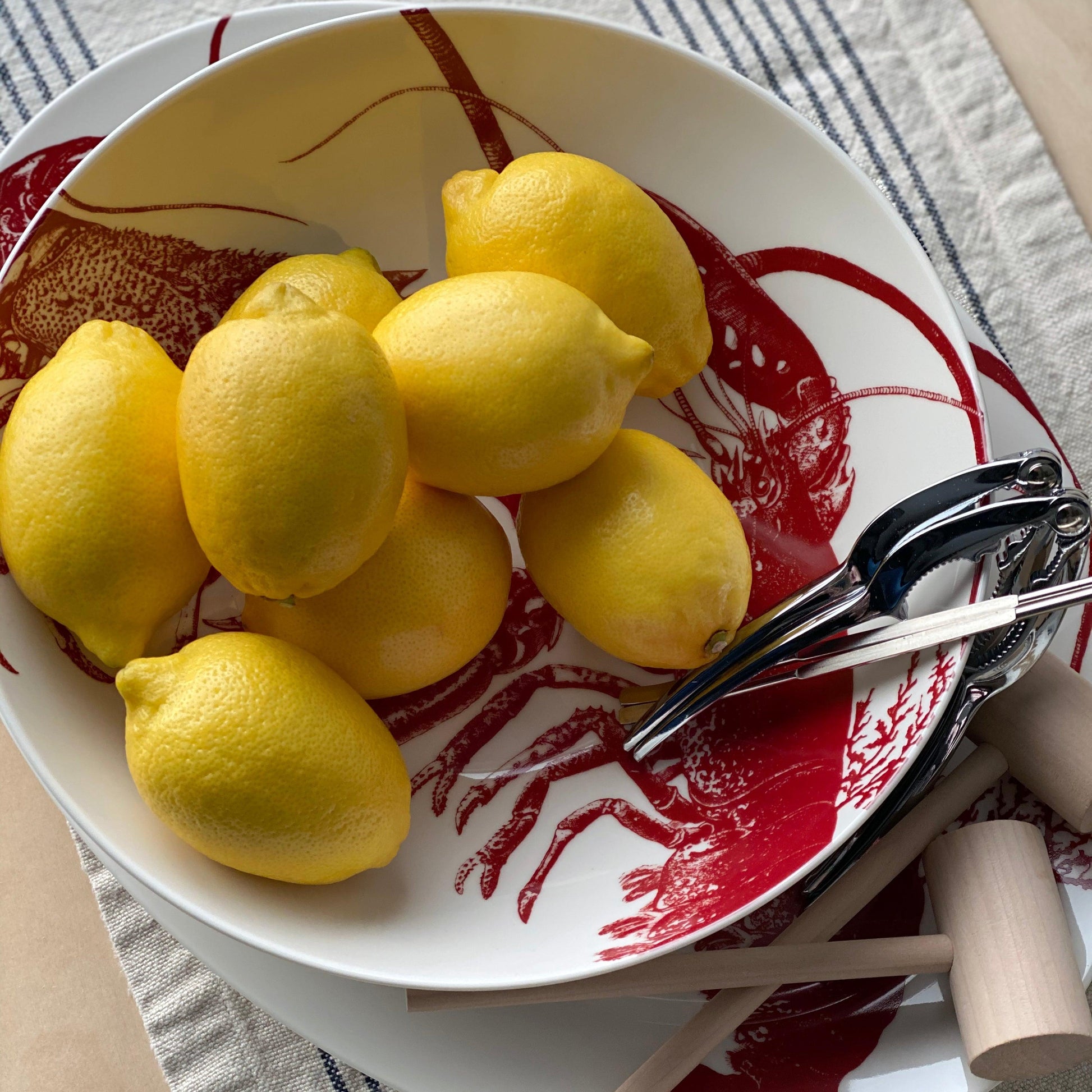 a bowl of lemons and a pair of scissors on a table