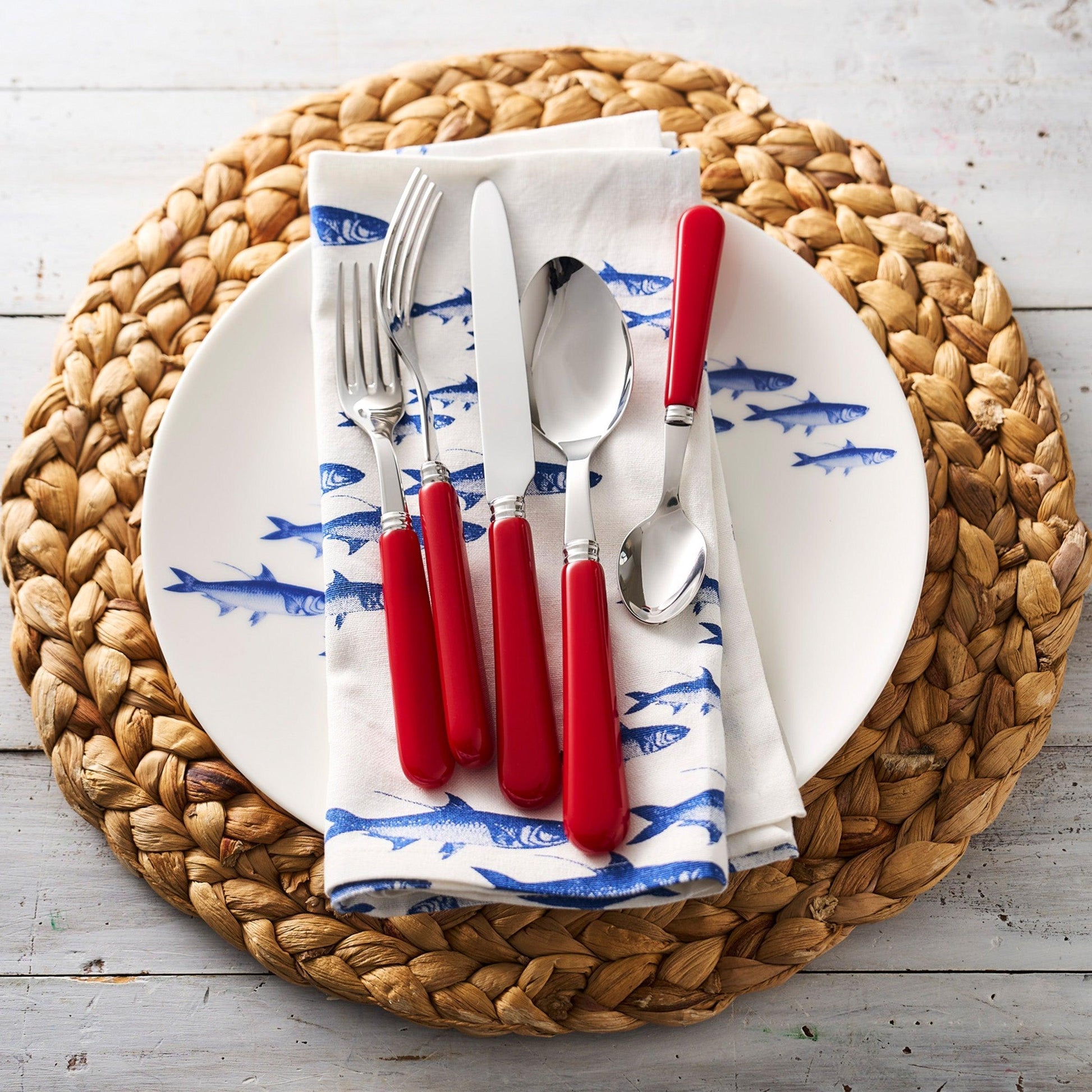 a white plate topped with red plastic utensils