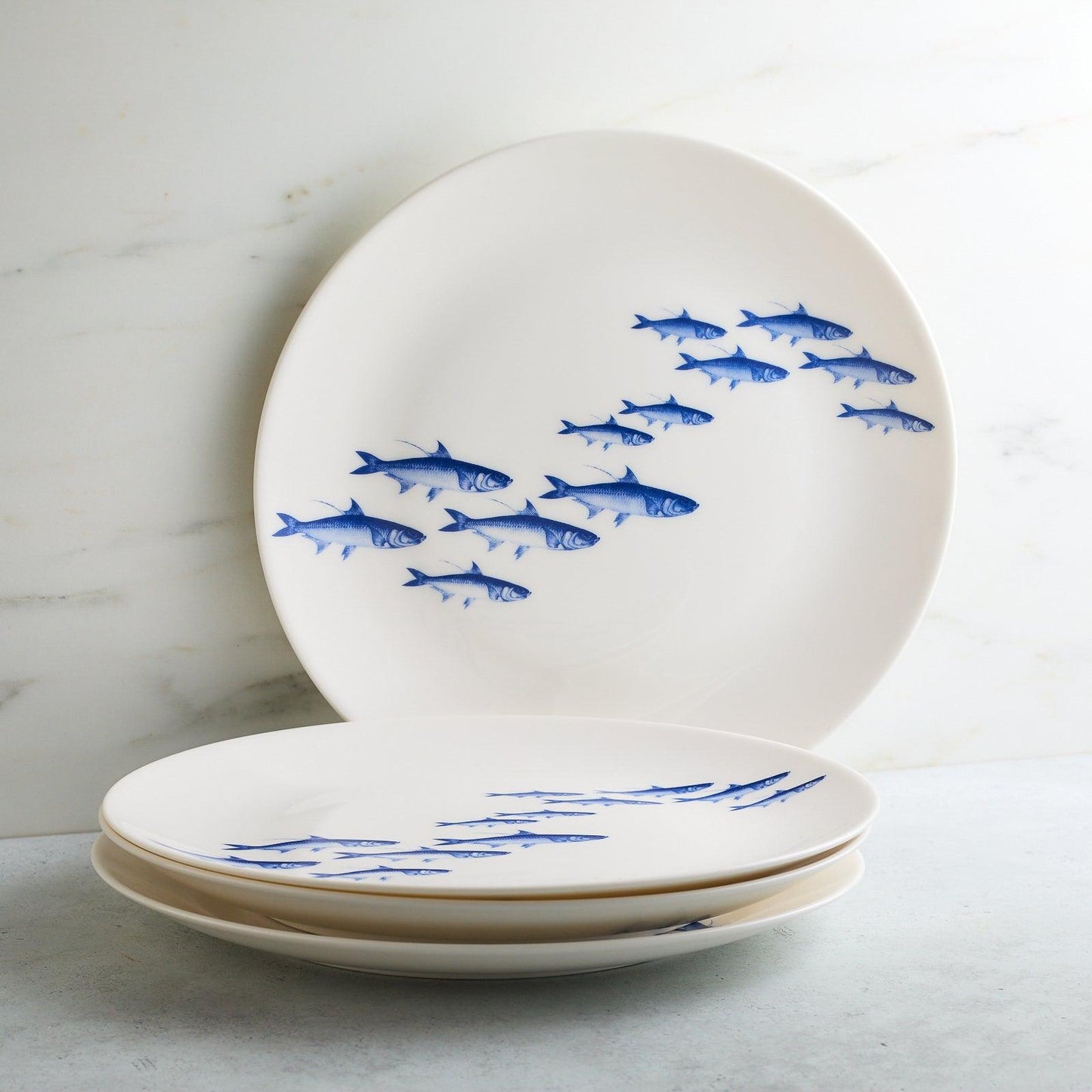 a white plate with blue fish on it