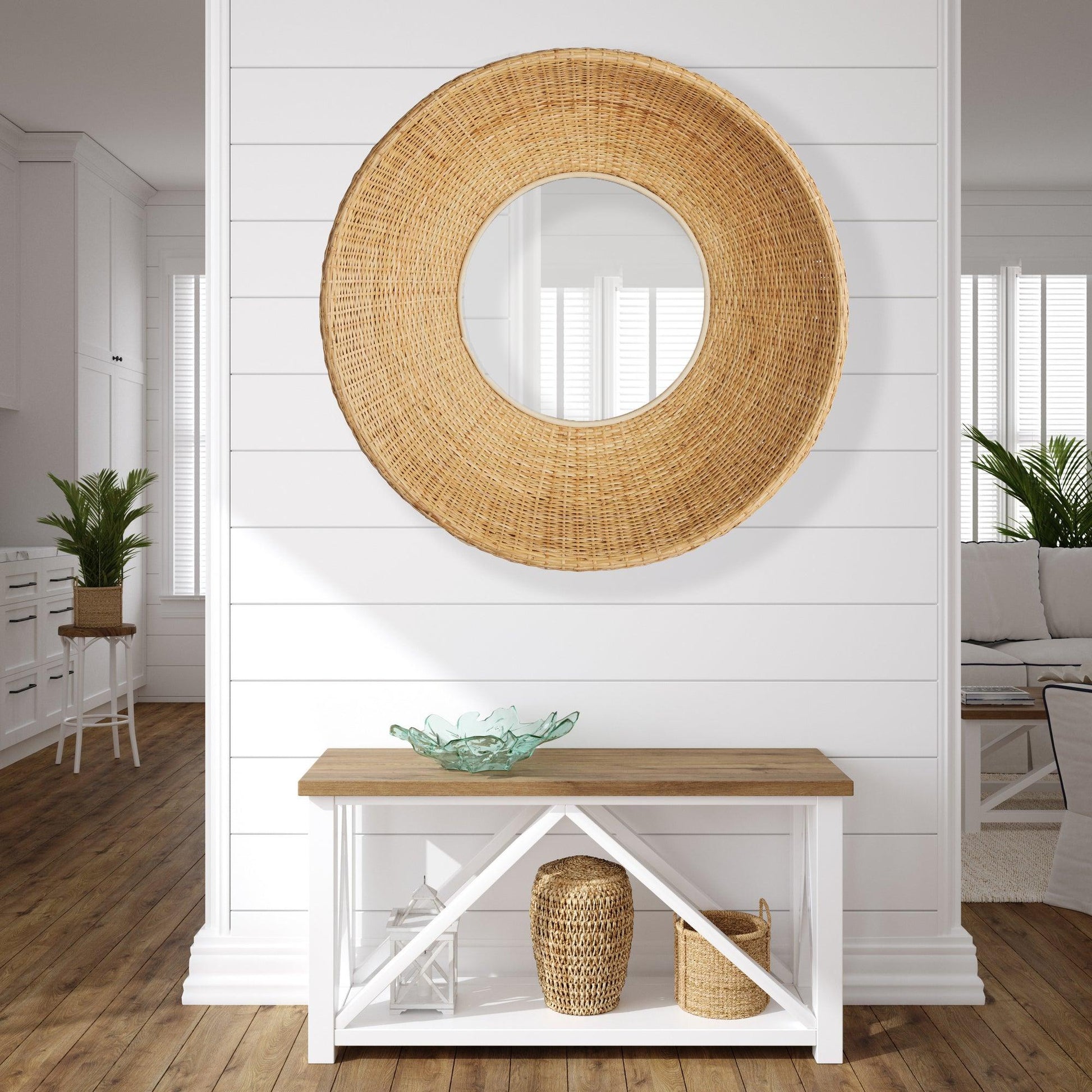 a wooden table sitting under a round mirror on a wall