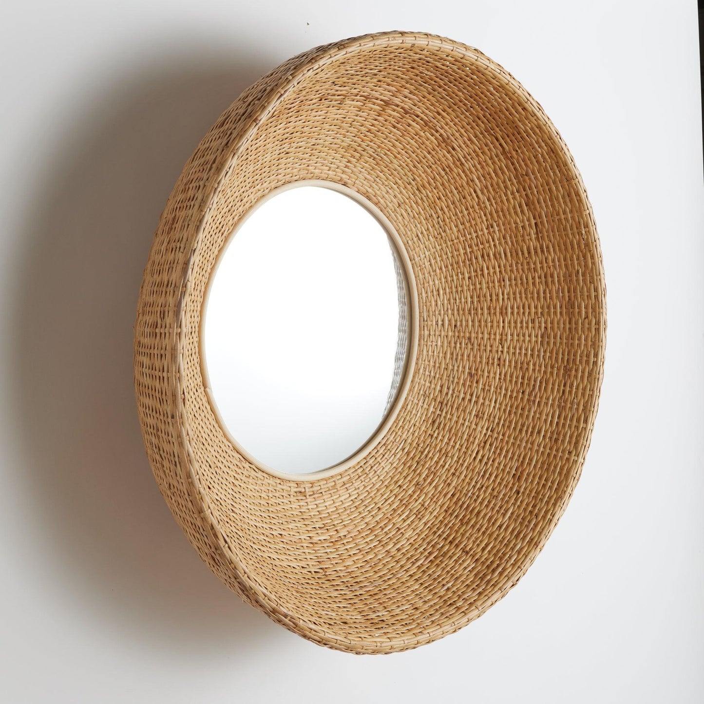 a round mirror sitting on top of a white wall