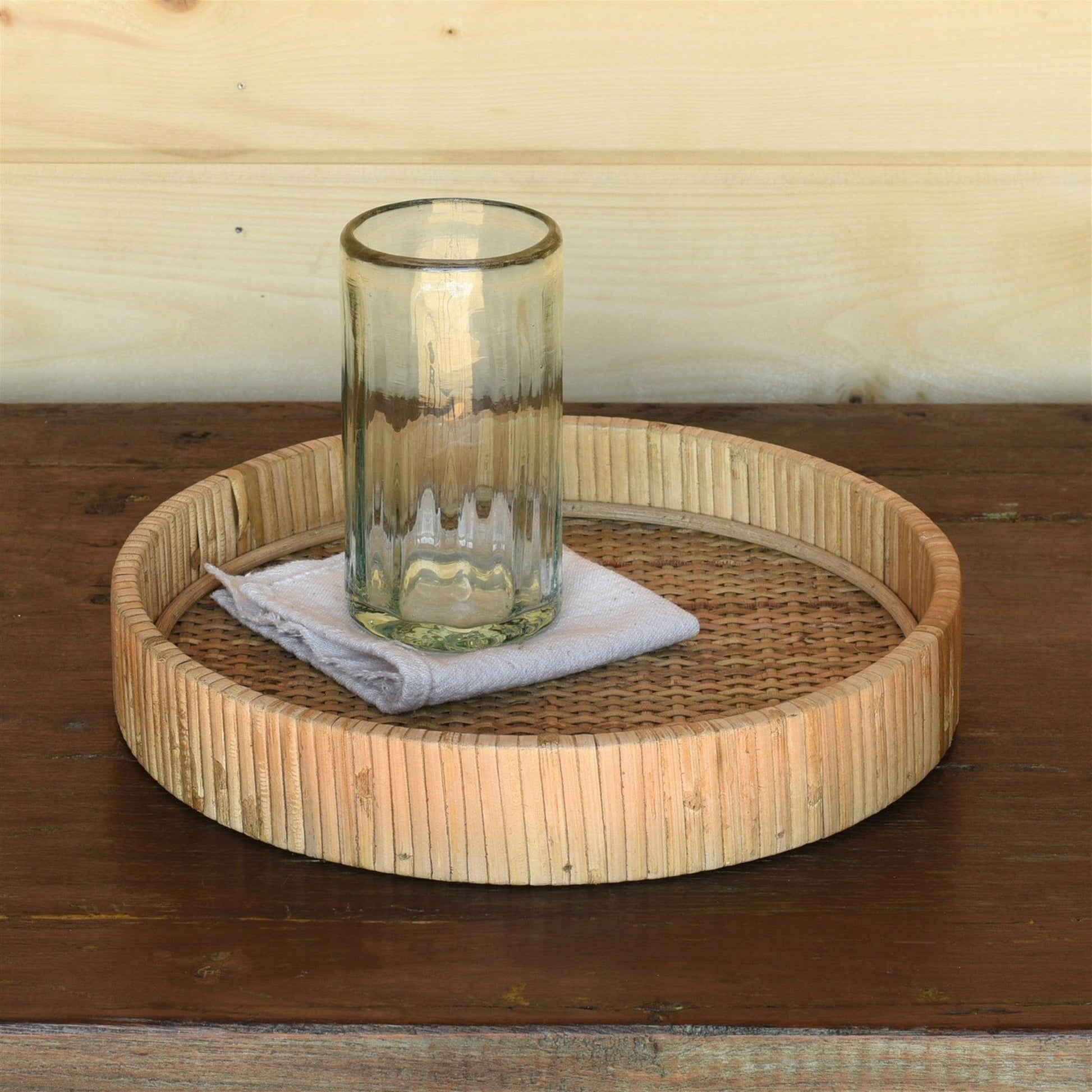 small round rattan tray with a glass