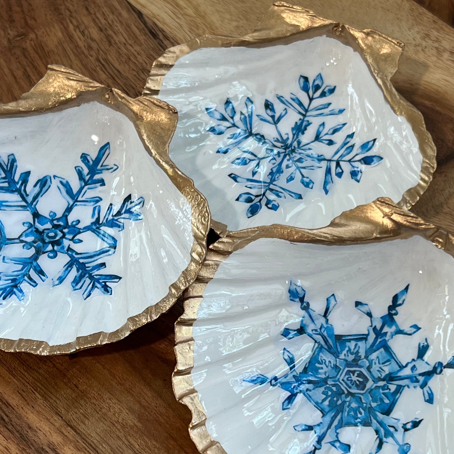 three gold and white decorations with blue snowflakes