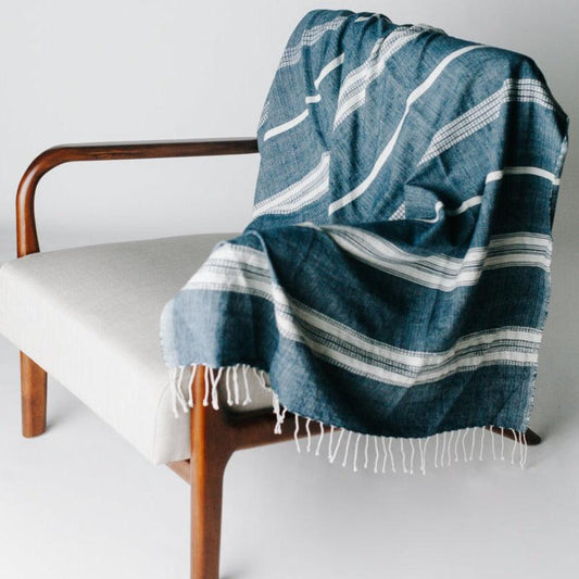 a blue and white blanket sitting on top of a wooden chair