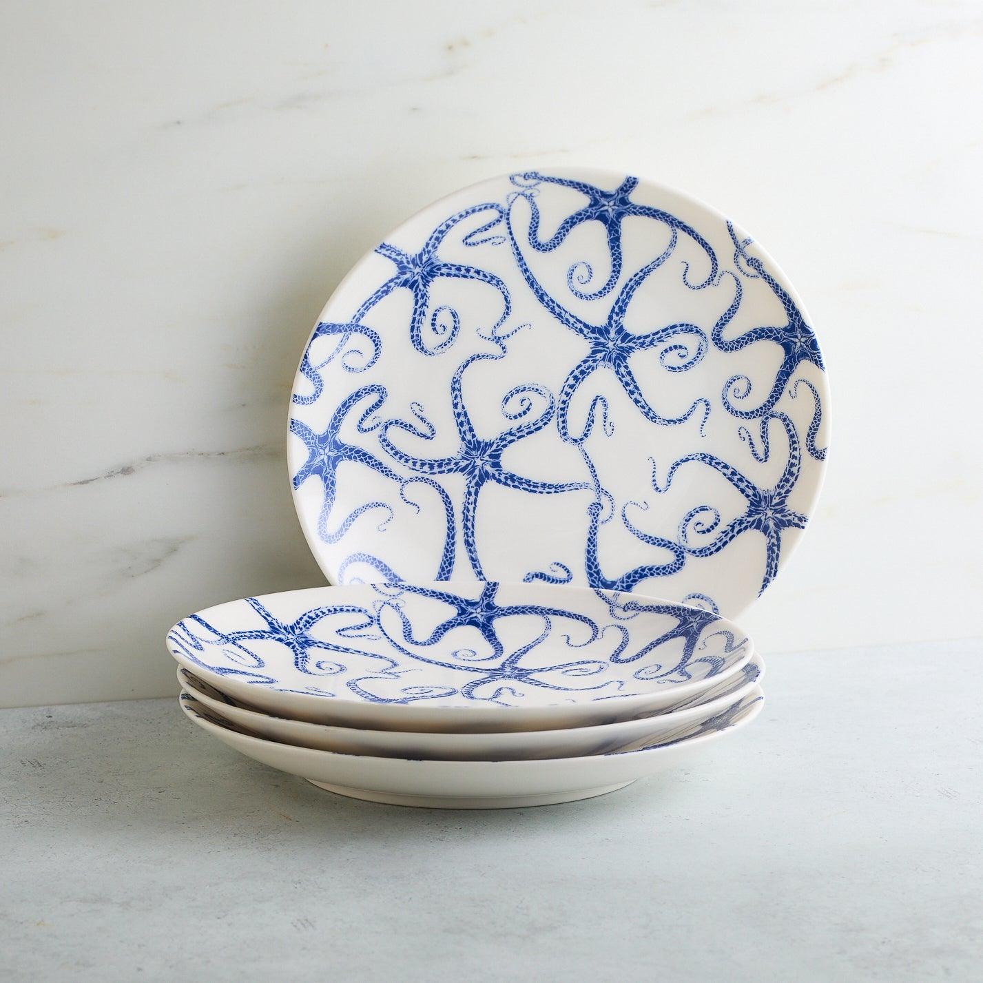 a stack of four blue and white plates