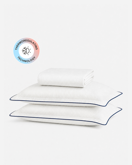 Porto cooling fitted sheet set with a folded white sheet, two blue-trimmed pillowcases, and a temperature-regulating badge