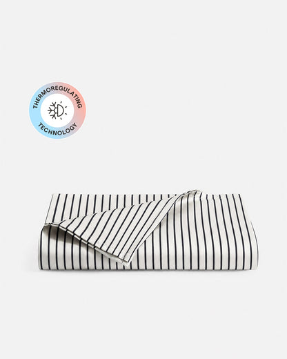 Folded Porto white and midnight blue striped top sheet with a temperature-regulating technology badge