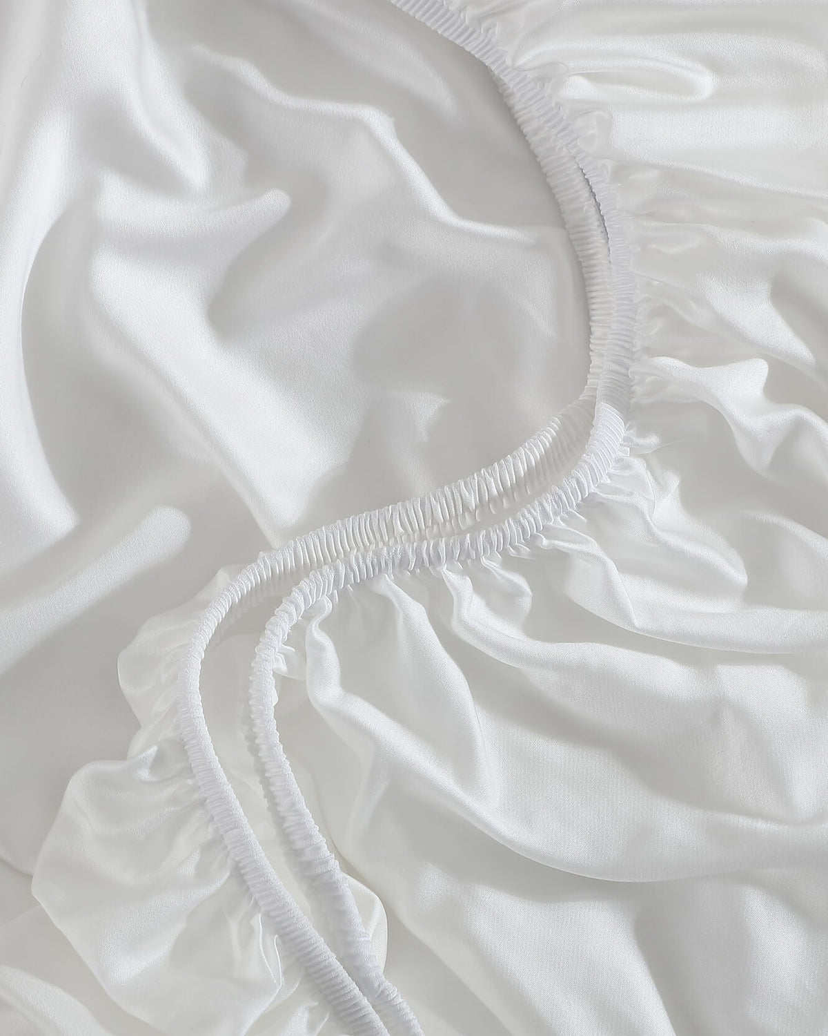 Close-up of the Porto white fitted sheet’s gathered elastic edge