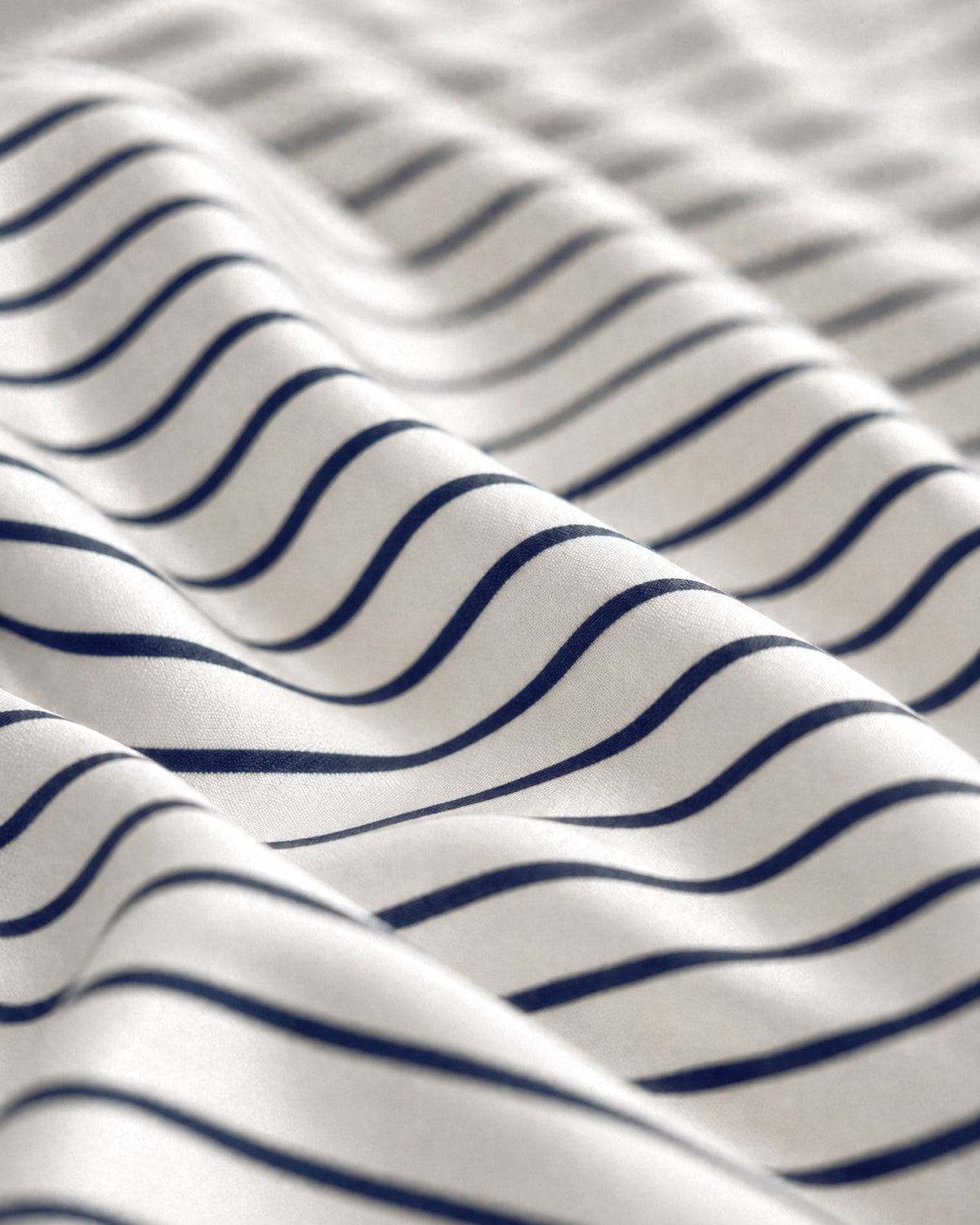 Close-up of Porto top sheet fabric showing midnight blue stripes on white
