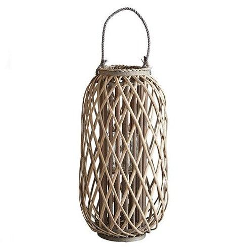 a rattan lantern hanging on a white wall