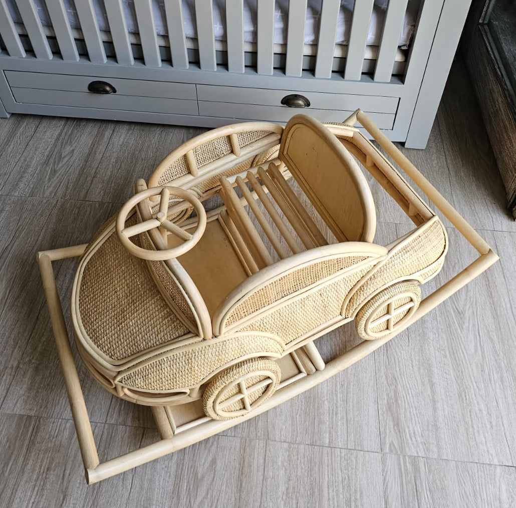 Overhead view of the rattan rocking car showing its steering wheel, seat, and back cushion
