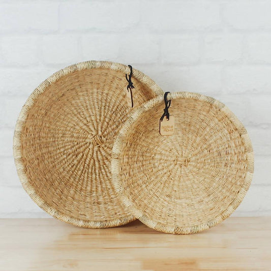 two woven baskets sitting on top of a wooden table