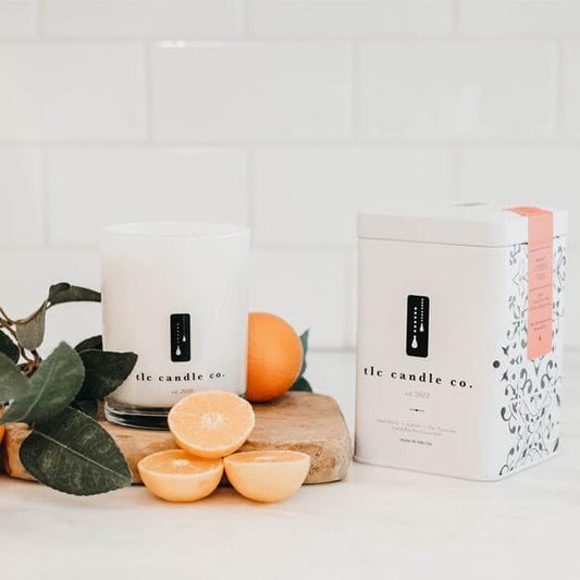 white candle with grapefruits on white counter