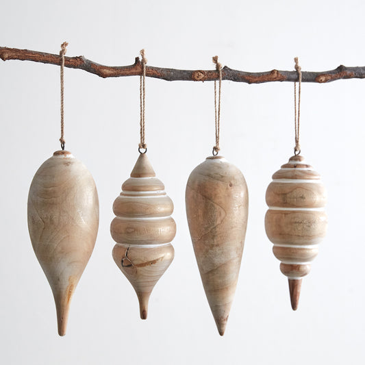 four wooden ornaments hanging on a branch