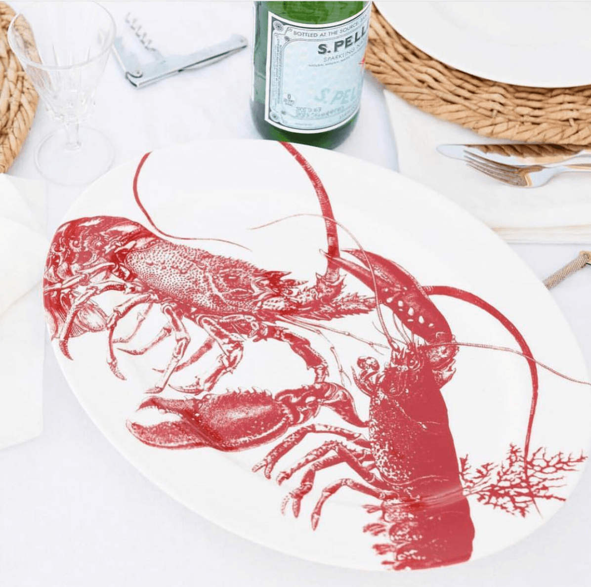 a white plate topped with a red drawing of a lobster