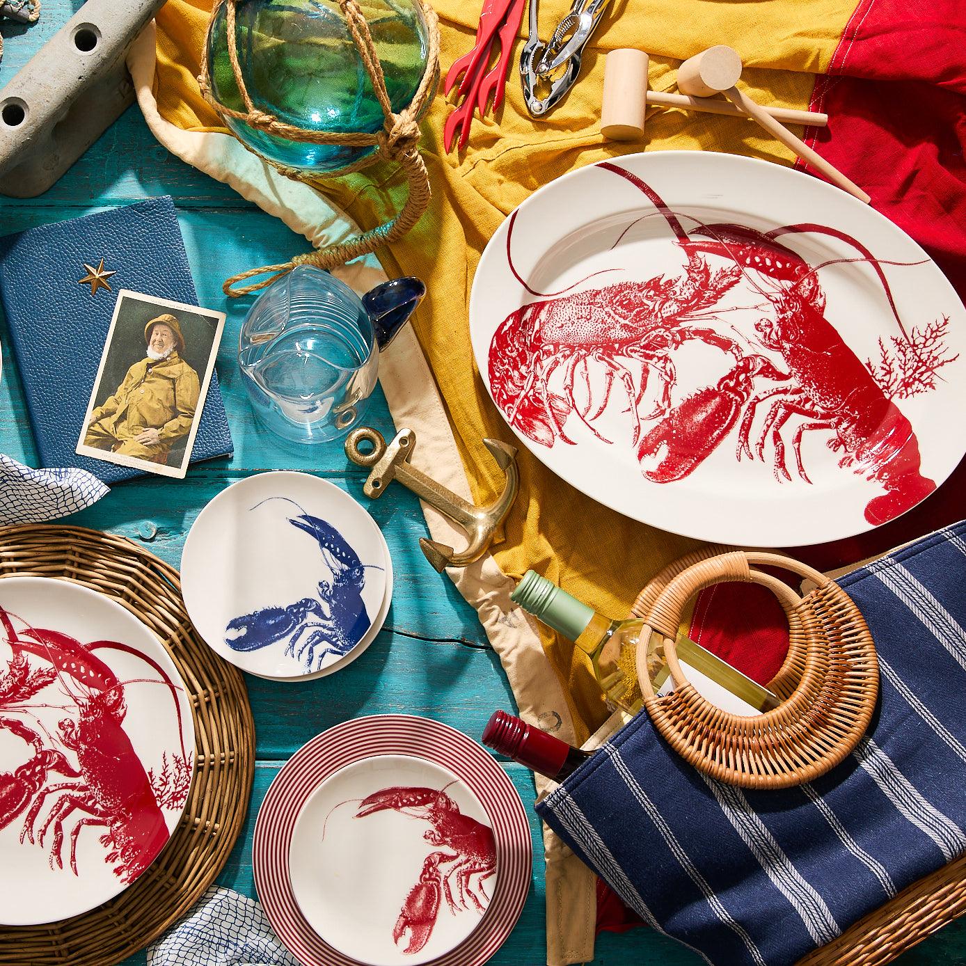 a table topped with plates covered in lobster designs